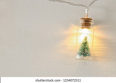 close up image of Christmas tree in the masson jar garland light over wooden white background - Powered by Shutterstock