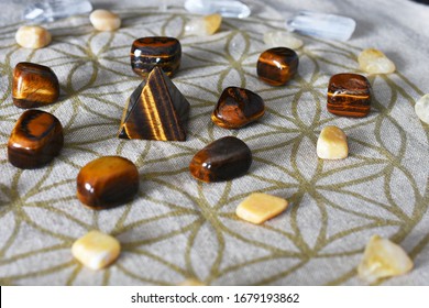 A close up image of a crystal prosperity grid using tigers eyes and citrine.