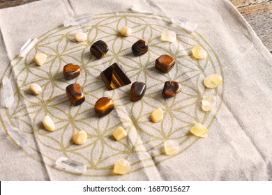 A close up image of a crystal prosperity grid using tiger's eye and citrine crystals.