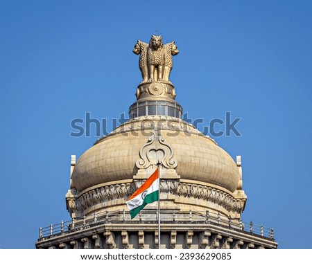 Close up image of dome of largest legislative building in India - Vidhan Soudha , Bangalore with nice blue sky background. Translation of text mentioned is Government work is God's work.