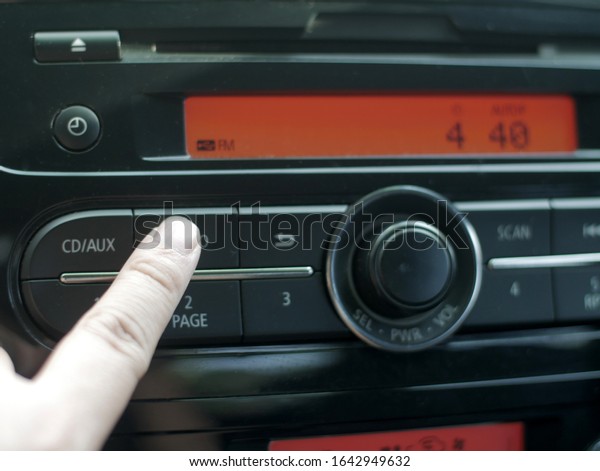 Close up image of driver\'s hand\
press button on car radio, listening music during trip\
concept