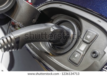 Close up image of an electric car is being charged at a charging station