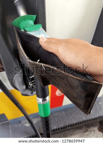 Close up image of empty wallet on the petrol pump. 