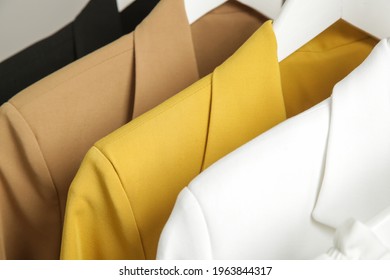 Close up image of fashionable tailored blazers hanging on a rack. Modern premium quality hand made woman's fashion.