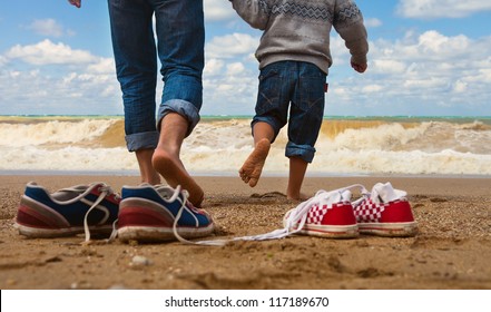 Close up image father and son legs walk at the seaside - Powered by Shutterstock