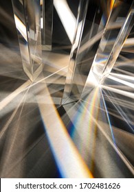 Close Up Image Of Group Of Crystal Clear Triangular Glass Prisms Refracting And Dispersing Narrow Beam Of Artificial Light Into Spectrum And Cross Line Pattern On Texture Paper. Triangular Pattern 