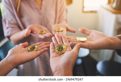 Close Up Image Of A Group Of People Holding A Golden Color Bitcoin In Hands