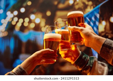 Close up image of hands holding glasses of beer and clinking after celebrating toast. Old friends sitting in bar and celebrating start of football season. Concept of Oktoberfest, party, traditions. - Powered by Shutterstock