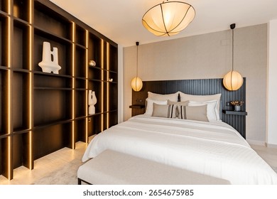 a close image of a large bed next to black wall cabinets in luxury mediterranean real estate 