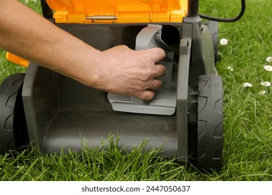 Close up image of lawn mower with inserted mulching plug, a cutting function that finely shreds the clippings and spreads it over the ground as a fertiliser.