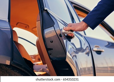 Close up image of a man opens car's door.