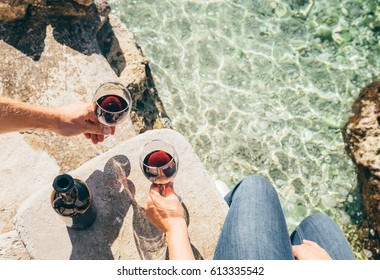 Close up image man and woman hands with goblet of wine at the sea side - Powered by Shutterstock