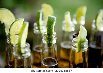 Close up image of multiple beer bottles with limes inserted