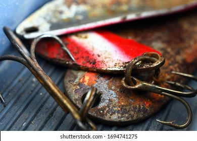 A close up image of old rusted fishing hooks in a grey fishing tackle box.  - Powered by Shutterstock