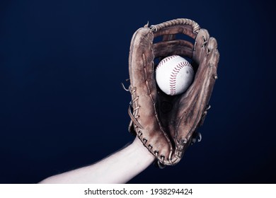 Close up image of an old used baseball and baseball glove.