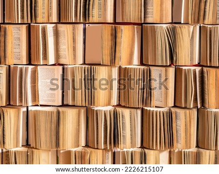Close up image of opened stack pile heap collection old books hard cover attached to the wall pages. Photo zone decoration background. Library books in shop or photostudio, education concept.
