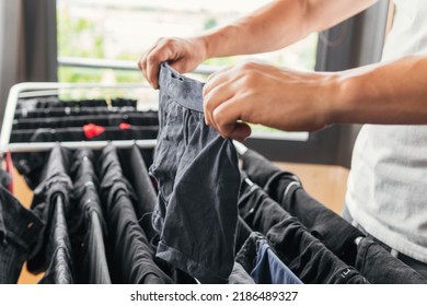 Acercar la imagen de las manos de una persona colgando ropa interior en un tendedero de metal interior. Los propietarios hacen las tareas domésticas felices y se contentan con sentirse satisfechos. Hombre terminando la lavandería.