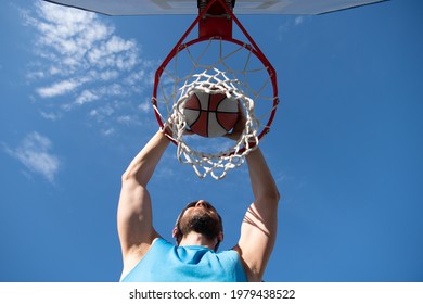 Close Up Image Of Professional Basketball Player Making Slam Dunk During Basketball Game In Outdoor Basketball Court.