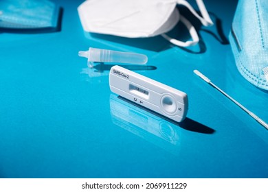 Close up image of Rapid test kit device for Covid-19 showing positive result. Lab card kit test for coronavirus SARS-CoV-2 virus. Fast test COVID-19 on blue surface - Shutterstock ID 2069911229