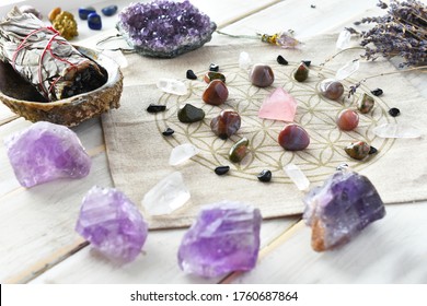 A close up image of a self love crystal grid using the flower of life sacred geometry grid cloth and amethyst crystals. 