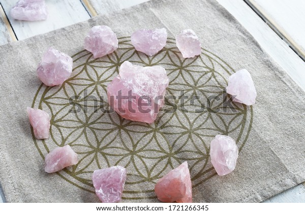 A close up image of a\
several rose quartz crystal in a energy healing grid using sacred\
geometry. 