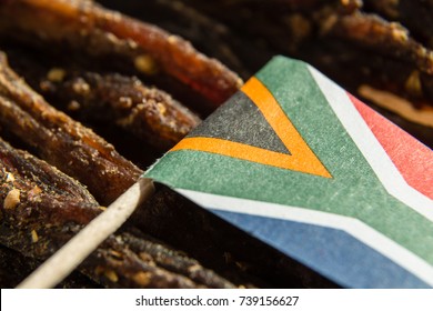 A Close Up Image Of A Small South African  Flag On Top Of Slices Of Biltong (cured Meat) Which Is A Traditional South African Food Snack. 