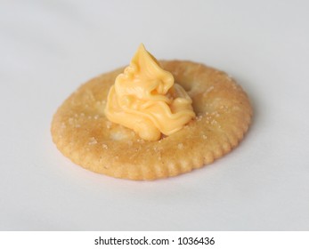 Close Up Image Of A Snack Cracker With Squeeze Cheese On Top