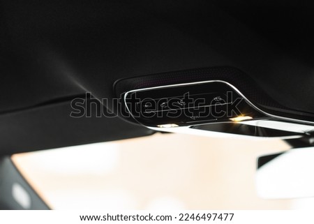 Close up image of the SOS button and car ceiling lamp in a car.