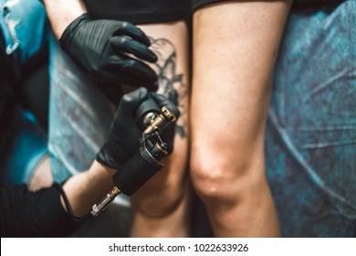 Close Up Image Of The Tattoo Male Artist Makes A Tattoo On A Female Leg.