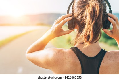 Close up image of teenager adjusting  wireless headphones before starting jogging and listening to music - Powered by Shutterstock