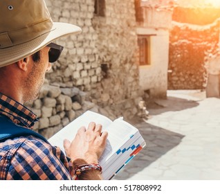 Close up image tourist with guide book on asian street - Shutterstock ID 517808992