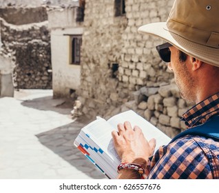 Close up image tourist with guide book on asian street - Shutterstock ID 626557676