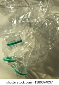 Close up image of twisted clear plastic bottle with shadow on ivory white background paper. 