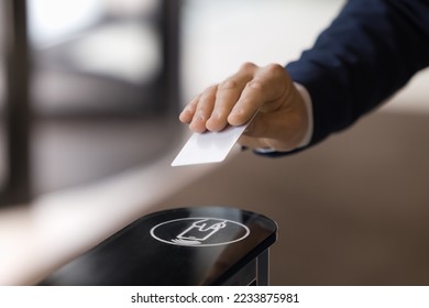 Close up image unrecognizable businessman hand using plastic pass card entering or leaving office modern workspace. Gateway and electronic card reader for area security, end or start of working day - Shutterstock ID 2233875981