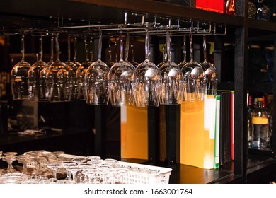 Close up image of wine glasses hang upside down on a counter at fine dining restaurant. - Powered by Shutterstock