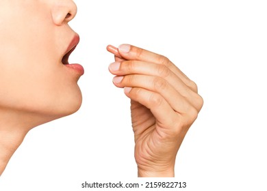 close up image of woman with her mouth open taking vitamin capsule isolate in white background - Shutterstock ID 2159822713