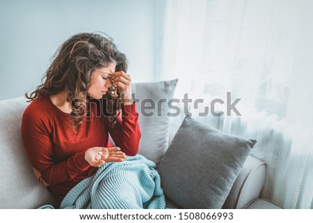 Close up image woman holding round pill and glass of still water taking painkiller to relieve painful feelings migraine headache, antidepressant or antibiotic medication, emergency treatment concept