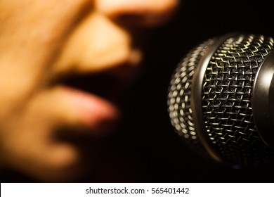 Close Up Image Of A Woman Singing To A Microphone.