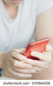 Close Up Image Of A Woman Using A Red Smartphone