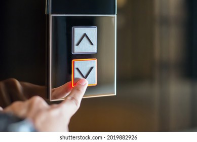 Close Up Image Of Young Female Was Using Her Finger To Press On The Elevator Botton Down In Office Building.