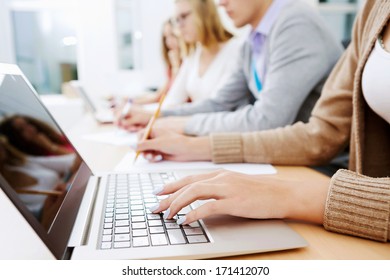 Close up image of young people using laptop at classroom
