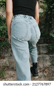 Close Up Image Of A Young Woman Wearing Mom Jeans Going Upstairs Outdoors. Close Up Image Styling And Fashion Concept With Copy Space