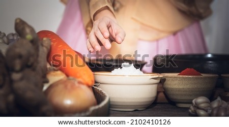 Close up images of Hand of Korean woman, she making Kimchi which is a fermented food preservation of Korean people consisting of many fresh vegetables and fruits