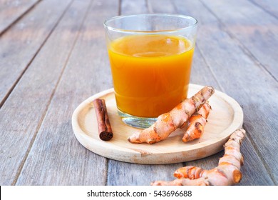 Close Up Of Immunity Boosting Spicy Turmeric Tea And Fresh Tumeric Roots On A Wooden Table. 