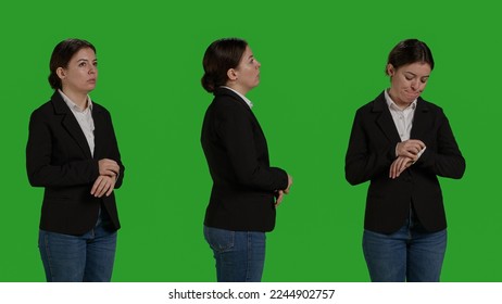 Close up of impatient office worker checking time on wristwatch, standing over isolated greenscreen backdrop. Young woman running late and looking at clock, waiting for something, - Powered by Shutterstock