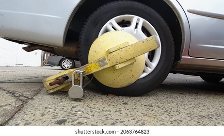 Close up of impounded car tire with yellow boot lock in New York City