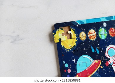 Close up of incomplete space puzzle with missing corner piece and copy space