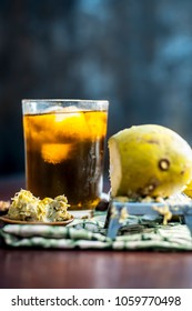 Close up of Indian and Asian famous mango juice AAM PANNA in a transparent glass with ice cubes and cardamoms,sugar,black salt and jaggery.