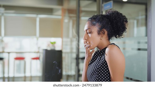 Close up of Indian curly hair young adult unhappy upset stress frustrated drug addicted expert business woman sitting alone smoking cigarettes hangover feel sad Lonely indoor job office work place.  - Powered by Shutterstock