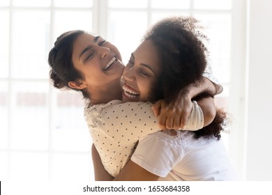 Close up indian and mixed race african ethnicity best girls friends intimates missed cuddle each other closed eyes enjoy moment showing sincere friendly attitude candid emotions congratulating concept